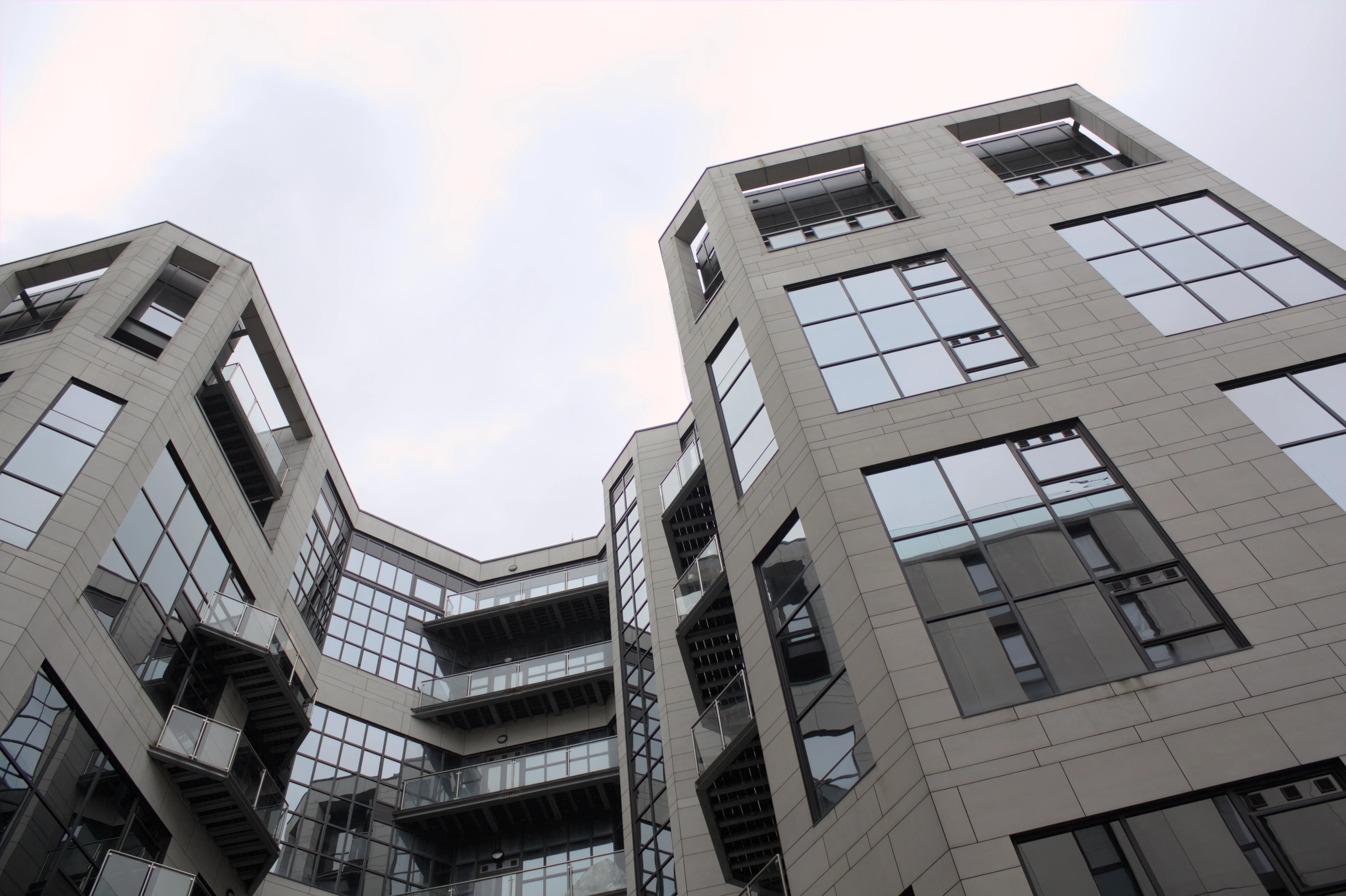 A geometric modern building with dark windows looming over the viewer