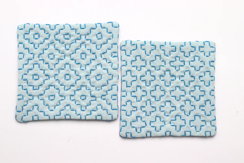 two coasters with kakinohana (flower like repeating grid patterns) blue embroidery