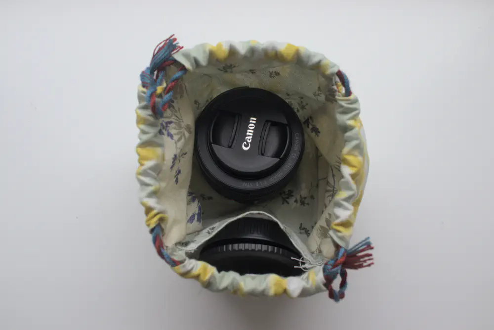 a canon lens inside the bag and lens caps in an inner pocket